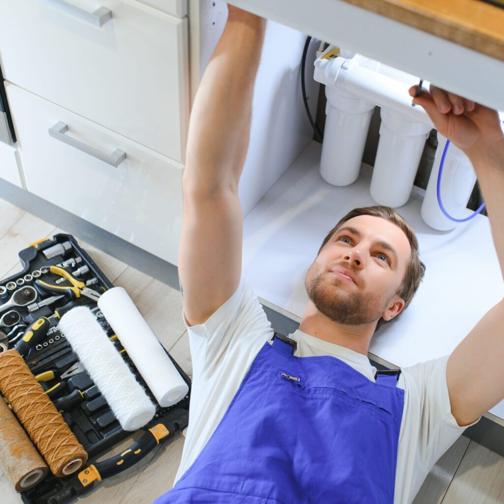 Technician installing a reverse osmosis bottleless water cooler